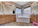 A spacious bathroom boasts dual vanities with a soaking tub in the middle beneath two windows at 6437 Boatbill St, North Las Vegas, NV 89084