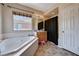 Bright bathroom features a soaking tub under a window, plus a vanity and shower at 6437 Boatbill St, North Las Vegas, NV 89084