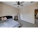 This bedroom is the perfect place to unwind and recharge with neutral light and a ceiling fan at 6437 Boatbill St, North Las Vegas, NV 89084