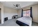 Cozy bedroom featuring neutral walls, a ceiling fan, and a window that offers plenty of natural light at 6437 Boatbill St, North Las Vegas, NV 89084