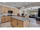 Kitchen featuring an island, wood cabinets, granite countertops, and stainless steel appliances at 6437 Boatbill St, North Las Vegas, NV 89084