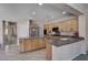 Open kitchen with light wood cabinets, dark countertops, and stainless steel appliances at 6437 Boatbill St, North Las Vegas, NV 89084
