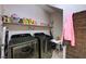 Functional laundry room with modern washer and dryer, and built-in shelving at 6437 Boatbill St, North Las Vegas, NV 89084