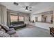 Open-concept living room with plush seating, ceiling fan, and adjacent kitchen at 6437 Boatbill St, North Las Vegas, NV 89084