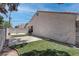 Residential backyard featuring small patio, synthetic grass area, and the side of home at 6624 Old Oxford Ave, Las Vegas, NV 89108