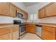 Traditional kitchen featuring wood cabinets, stainless steel appliances, and tile floors at 6624 Old Oxford Ave, Las Vegas, NV 89108