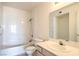 Clean bathroom featuring a shower-tub combo with white tile, a vanity with storage, and a bright mirror at 698 S Racetrack Rd # 1014, Henderson, NV 89015