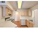 Bright kitchen with wood cabinets, white appliances, and a functional layout for efficient cooking and meal preparation at 698 S Racetrack Rd # 1014, Henderson, NV 89015
