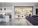 Bright living room with concrete floors seamlessly transitions to an outdoor patio with stylish furniture at 7030 Schirlls St, Las Vegas, NV 89118
