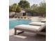Inviting pool area with tanning chairs and lush landscaping creates a backyard oasis at 7030 Schirlls St, Las Vegas, NV 89118