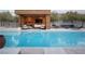Gorgeous pool area with an outdoor lounge and inviting pool house for entertaining at 7030 Schirlls St, Las Vegas, NV 89118