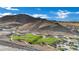 Expansive aerial shot showcasing a verdant community park nestled against a rugged desert mountain backdrop at 708 Kibbey St, Las Vegas, NV 89178