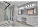 Spacious bathroom featuring a double vanity with large mirrors, a glass-enclosed shower, and clean neutral finishes at 708 Kibbey St, Las Vegas, NV 89178