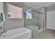 Clean bathroom showcasing a glass shower enclosure adjacent to a soaking tub beneath a window at 708 Kibbey St, Las Vegas, NV 89178