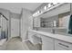 Well-lit bathroom with double vanity, large mirror, and glass-enclosed shower, all in neutral tones at 708 Kibbey St, Las Vegas, NV 89178