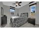 Bedroom featuring a patterned bed, two windows, and a ceiling fan at 708 Kibbey St, Las Vegas, NV 89178
