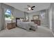 Cozy primary bedroom with plush carpet, ceiling fan, and windows dressed with patterned valances and curtains at 708 Kibbey St, Las Vegas, NV 89178