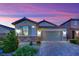 Charming single-story home with a two-car garage, desert landscaping and beautiful dusk lighting at 708 Kibbey St, Las Vegas, NV 89178