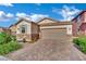 Single-story home showcasing a brick driveway, a two-car garage, and low-maintenance landscaping at 708 Kibbey St, Las Vegas, NV 89178
