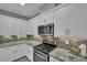 Modern kitchen featuring stone countertops, stainless steel oven and microwave, and tiled backsplash at 708 Kibbey St, Las Vegas, NV 89178