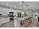Modern kitchen with white cabinets, stainless steel appliances, granite counters and island with bar stool seating at 708 Kibbey St, Las Vegas, NV 89178