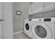 Bright laundry room with modern appliances and built in upper cabinetry at 708 Kibbey St, Las Vegas, NV 89178