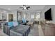 Relax in the living room featuring tile floors, ceiling fan, and comfortable sectional sofa with blue throw pillows at 708 Kibbey St, Las Vegas, NV 89178