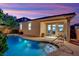 Backyard pool featuring a baja step, mature landscaping, and a covered patio with sliding glass doors at 708 Kibbey St, Las Vegas, NV 89178