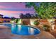 Inviting backyard pool with stone trim and mature trees at dusk at 708 Kibbey St, Las Vegas, NV 89178