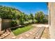 Lush backyard with artificial turf, mature trees, and rock landscaping at 7083 Somera Way, Las Vegas, NV 89113