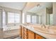 The bright bathroom features double sinks, soaking tub, and stand up shower at 7083 Somera Way, Las Vegas, NV 89113