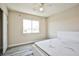 This cozy bedroom features neutral walls, a ceiling fan, and a window letting in natural light at 7083 Somera Way, Las Vegas, NV 89113