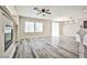 Spacious living room featuring gray-toned wood flooring, a fireplace, and a ceiling fan at 7083 Somera Way, Las Vegas, NV 89113