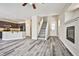 Open-concept living space featuring sleek flooring, modern kitchen, and inviting fireplace at 7083 Somera Way, Las Vegas, NV 89113