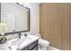 Modern half bathroom featuring a decorative accent wall, unique mirror, and marble countertops at 722 Descartes Ave, Henderson, NV 89002