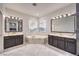 Bright bathroom with double sinks, a soaking tub, and large mirrors offering a luxurious spa-like experience at 722 Descartes Ave, Henderson, NV 89002