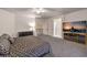 Spacious bedroom featuring a patterned bedspread, ceiling fan, and entertainment center with a large television at 722 Descartes Ave, Henderson, NV 89002