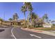 Welcoming entrance to Palm Hills community with lush landscaping, mature palm trees, and mountain views at 722 Descartes Ave, Henderson, NV 89002