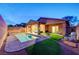 Backyard with a refreshing pool, covered patio, artificial turf, and desert landscaping at 7235 Summer Air Ave, Las Vegas, NV 89179