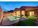 Expansive backyard featuring a pool, covered patio, and well-maintained artificial turf at 7235 Summer Air Ave, Las Vegas, NV 89179