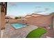 Serene backyard pool area with lovely brickwork, artificial grass, and umbrella for sun-soaked outdoor relaxation at 7235 Summer Air Ave, Las Vegas, NV 89179