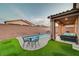 Inviting backyard with a refreshing pool, cozy patio seating, and lush artificial grass for outdoor enjoyment at 7235 Summer Air Ave, Las Vegas, NV 89179