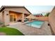 Charming backyard featuring a sparkling pool, covered patio with stylish furniture, and lush artificial grass at 7235 Summer Air Ave, Las Vegas, NV 89179