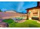 A relaxing backyard with a shimmering pool, covered patio, and lush artificial turf at 7235 Summer Air Ave, Las Vegas, NV 89179