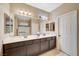 Bathroom featuring double sinks, large mirror, and glass door shower at 7235 Summer Air Ave, Las Vegas, NV 89179