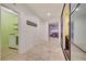 Hallway with stone tile leading to living area and laundry room with shelves and modern washer and dryer at 7235 Summer Air Ave, Las Vegas, NV 89179