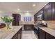 Bright kitchen with dark cabinets, granite countertops, stainless appliances, and an island at 7235 Summer Air Ave, Las Vegas, NV 89179