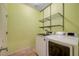 Practical laundry room features a washer, dryer, and metal shelving at 7235 Summer Air Ave, Las Vegas, NV 89179