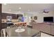 Open-concept kitchen and living area with stainless appliances, tile floors, and a comfortable sectional sofa at 7235 Summer Air Ave, Las Vegas, NV 89179