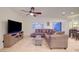 Bright living room featuring tile floors, a large TV, a comfortable sectional sofa, and plenty of natural light at 7235 Summer Air Ave, Las Vegas, NV 89179